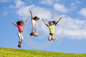 Group three jumping girls over clean blue sky