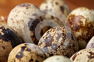 Group of three quail eggs on a wooden table, top view, close-up, selective focus, copy space.