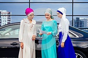 Group of three successful business multinational Muslims women in stylish veiled hijab a turban headscarf is tied up on