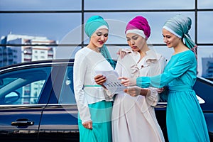 Group of three successful business multinational Muslims women in stylish veiled hijab a turban headscarf is tied up on