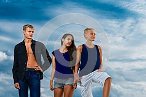 A group of three teenagers on the beach purposeful looks. The sk