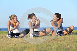 Group of three women stretching after sport