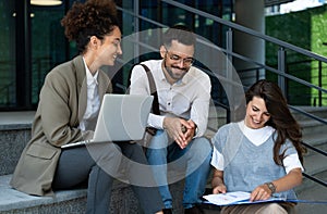 Group of three young business people experts in marketing telecommuting financial and strategy, talking outside office building.