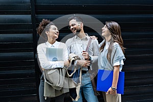 Group of three young business people experts in marketing telecommuting financial and strategy, talking outside office building.