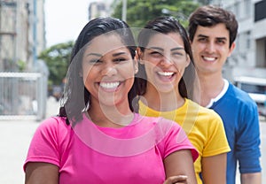 Group of three young people in colorful shirts standing in line