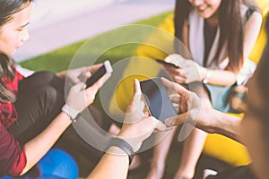 Group of three young people using smartphones together, modern lifestyle or communication technology gadget concept