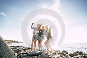 Group of three young woman dance on the beach