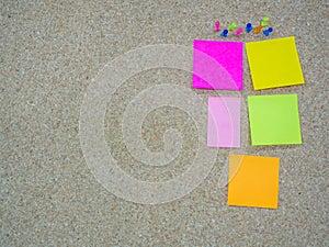 Group of thumbtacks pinned and paper note on cork board