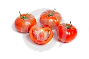 a group of tomatoes on a white background, with shadows. One tomato cut, studio photo, isolate, tomatoes washed
