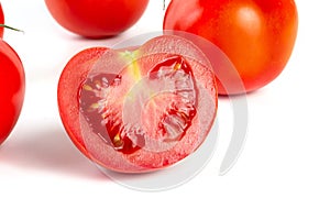 a group of tomatoes on a white background, with shadows. One tomato cut, studio photo, isolate, tomatoes washed