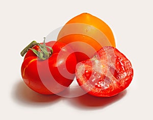 Group of tomatoes on a white background.Two whole tomatoes and half.