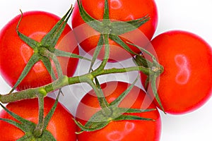 a group of tomatoes on a white surface with green stems on top of them, with a white background