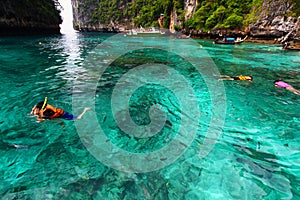 Group of Tourism on trip in life jacket with diving mask is snorkeling among many Indo- Pacific sergeant fish