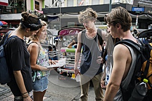 Group of tourists checking on Bangkok Thailand travel guide book