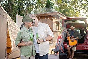 Group tourists drinking beer-alcohol and play guitar together with enjoy and happiness in Summer while camping