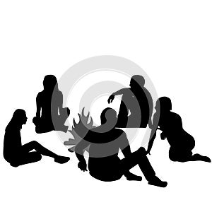 Group of tourists relaxing near campfire