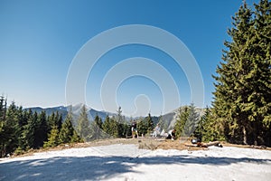 A group of tourists sat down to rest on a snow-capped peak while climbing a mountain on a sunny spring day