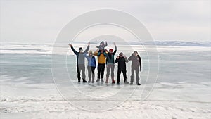 A group of tourists travels along the ice of the frozen Lake Baikal. Clip. Aerial view of happy people waving to the