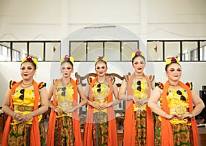 a group of traditional Sundanese dancers standing with their friends before the performance starts