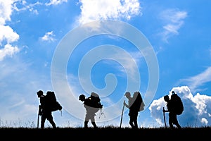 Group of travellers with backpacks on top of mountain