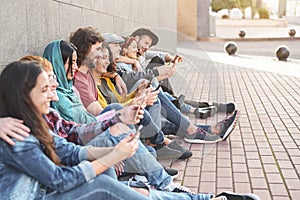 Group trendy friends using smart mobile phones outdoor - Millennial people having fun with new technology trends smartphone