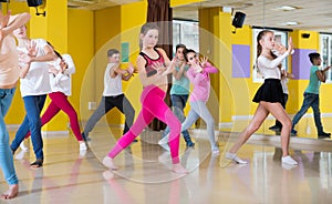 Tweens exercising with coach in choreography class photo