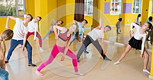 Tweens exercising with coach in choreography class