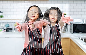 Group of two Diverse Family, Asian and Arab Preschool kid person make Cake cooking in kitchen, little girl shows dirty hands