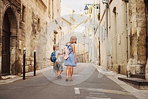 Group of two kids walking on the streets of old european town