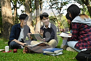 Group of university students learning together while sitting under the tree. Relationship, youth and community concept