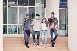 Group of university students walking outside together in campus, Happy Diverse students team concept.