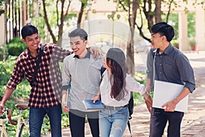 Group of university students walking outside together in campus, Happy Diverse students team concept.