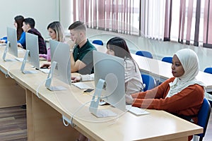 Group of  university IT technologies students working on practice lessons. Sitting near therir computer and looking for solution