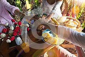 Group Of Unrecognizable People At Breakfast Table Holding Pineapple In Hands Together Young Man And Woman In Morning