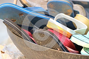 Group of used footwear placed in a basket, Colorful flipflop in a basket