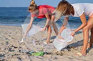 Group of volunteers cleaning up beach line. People tidying up rubbish on sea shore. Ecology concept