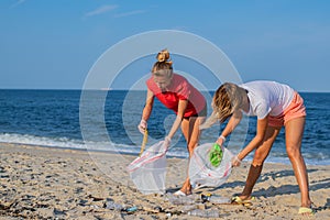 Group of volunteers cleaning up beach line. People tidying up rubbish on sea shore. Ecology concept