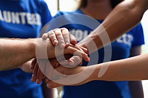 Group of volunteers joining hands together