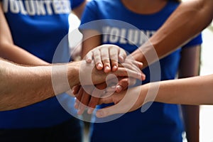 Grupo de voluntarios uniendo manos común 