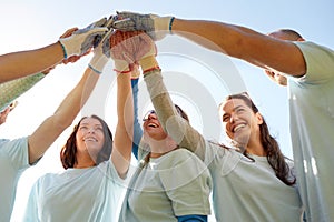 Group of volunteers making high five outdoors