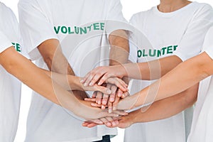 Group of volunteers putting hands together photo