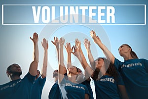 Group of volunteers raising hands outdoors photo