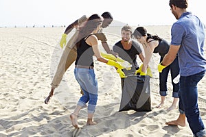 Group Of Volunteers Tidying Up Rubbish On Beach