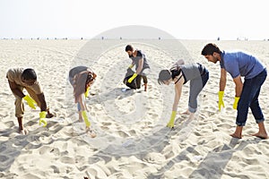 Group Of Volunteers Tidying Up Rubbish On Beach photo