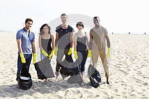Group Of Volunteers Tidying Up Rubbish On Beach