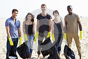 Group Of Volunteers Tidying Up Rubbish On Beach