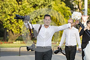 A group of wedding photographers on the streets of Budapest is holding a photo session for a couple of newlyweds.