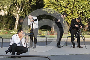 A group of wedding photographers on the streets of Budapest is holding a photo session for a couple of newlyweds.