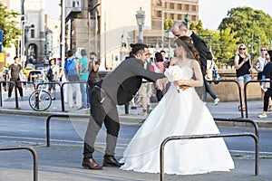 A group of wedding photographers on the streets of Budapest is holding a photo session for a couple of newlyweds.