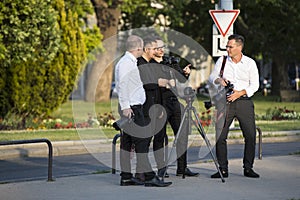 A group of wedding photographers on the streets of Budapest is holding a photo session for a couple of newlyweds.